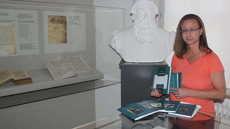 Stadtarchivarin Adelheid Waschka mit dem neuen Buch über das Leben des Rechenmeisters im Adam-Ries(e)-Raum des Staffelsteiner Museums Foto: Matthias Einwag