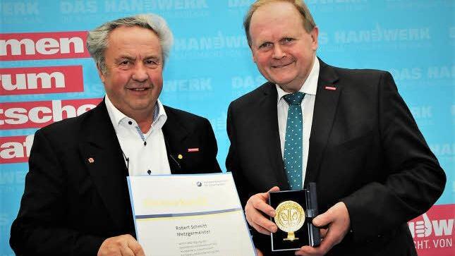 Als letzte Amtshandlung zeichnete der scheidende Kammerpräsident Hugo Neugebauer (67, rechts) den Bad Kissinger Metzgermeister Robert Schmitt (72) für seine Verdienste um das Metzgerhandwerk mit dem goldenen Siegel der unterfränkischen HWK aus. Foto: Daniel Röper