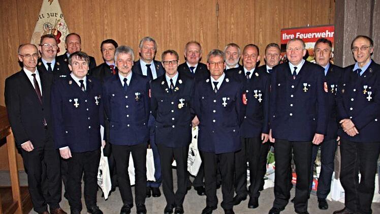 Elf aktive Feuerwehrleute aus dem Stadtgebiet von Ebern wurden für ihre Verdienste durch Landrat Wilhelm Schneider (links) geehrt. Mit auf dem Foto (hinten weiter von links) Kreisbrandrat Ralf Dressel, Kreisbrandmeister Thomas Habermann, MdL Steffen Vogel und Bürgermeister Jürgen Hennemann. Fotos: Helmut Will