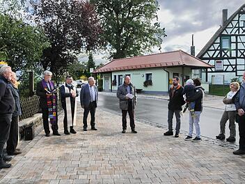 Der neugestaltete Dorfplatz in Honings mit "Milchhäusla" und barrierefreier Bushaltestelle. Projektleiter Werner Bauer (M.) vom ALE Oberfranken erläuterte den Ablauf der Dorferneuerung. Foto: Karl Heinz Wirth