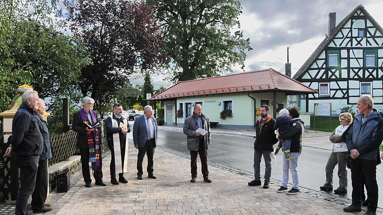 Der neugestaltete Dorfplatz in Honings mit "Milchhäusla" und barrierefreier Bushaltestelle. Projektleiter Werner Bauer (M.) vom ALE Oberfranken erläuterte den Ablauf der Dorferneuerung. Foto: Karl Heinz Wirth