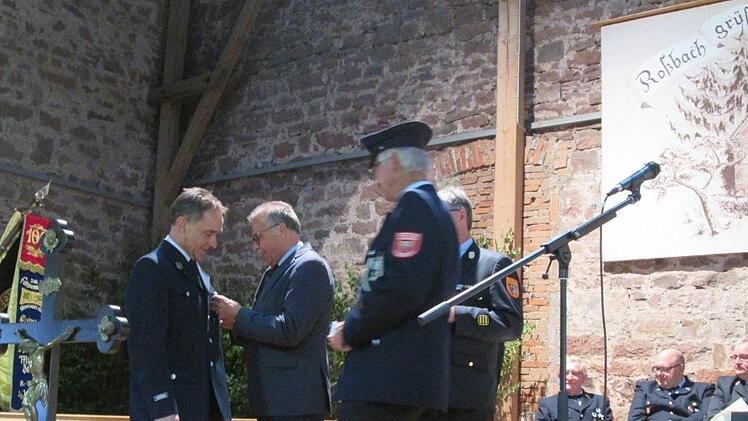 Rudi Leuber erhält die Ehrennadel von Emil Müller angesteckt, rechts daneben Kreisbrandinspektor Marco Brust. Foto: Diana Leitsch