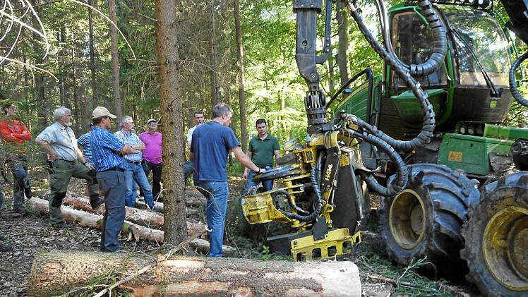 Respektvoll staunend lassen sich die Teilnehmer an der Waldbegehung die Arbeitsweise eines Harvesters, eines Holzvollernters, erklären. Fünfter von links Bürgermeister Günther Pfeiffer, Dritter von rechts der Lenker der Riesenmaschine, Julian Reith. Foto: Klemens Albert