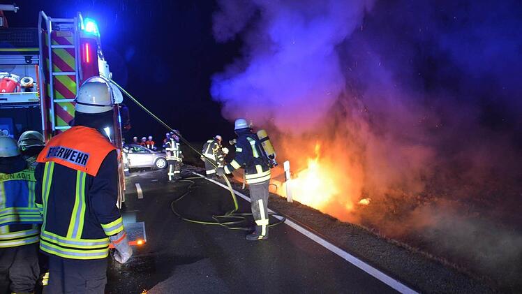 Als die Feuerwehrleute und der Rettungsdienst am Montagabend an der Unfallstelle zwischen Aub und Gabolshausen ankommen, steht das Auto bereits lichterloh in Flammen. Für Fahrerin und Beifahrerin kam jede Hilfe zu spät.  Foto: Hanns Friedrich