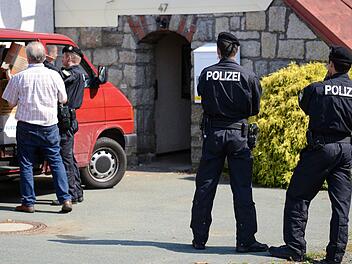Polizeibeamte tragen Beweismittel aus dem beschlagnahmten ehemaligen Gasthof in Oberprex, der von Rechtsextremen vor wenigen Jahren gekauft worden war und als Treffpunkt der rechten Szene diente. Von hier aus wurde wohl auch Propagandamaterial verschickt.  Foto: David Ebener/dpa