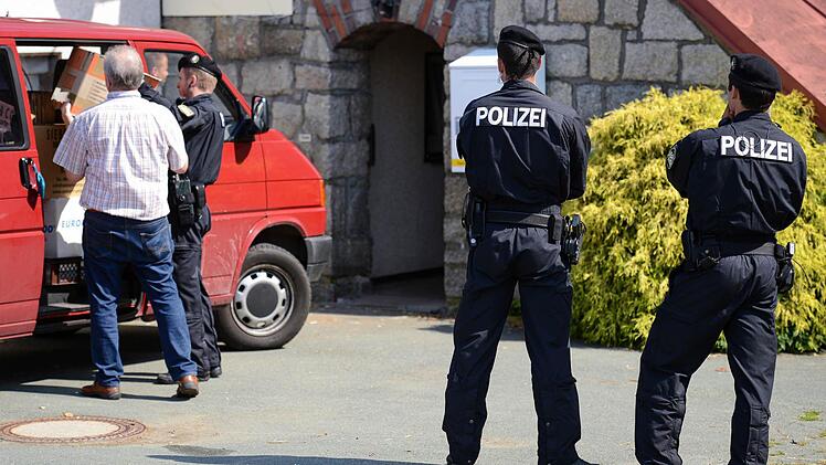 Polizeibeamte tragen Beweismittel aus dem beschlagnahmten ehemaligen Gasthof in Oberprex, der von Rechtsextremen vor wenigen Jahren gekauft worden war und als Treffpunkt der rechten Szene diente. Von hier aus wurde wohl auch Propagandamaterial verschickt.  Foto: David Ebener/dpa