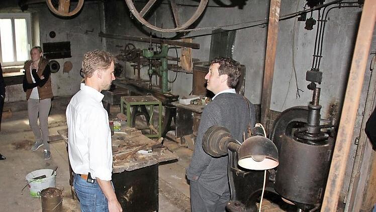 Anton Gerstenkorn in der einstigen Werkstatt des Vorbesitzers "Peter Fuchzich", einem Meister seines Fachs, wo die Zeit stehen geblieben ist, im Gespräch mit Christian Schmidt vom Landesamt für Denkmalpflege. Man beachte: Die Transmissions-Riemen und -Räder an der Decke. Im Hof finden sich noch Schilder der früheren Tankstelle dort.  Fotos : Ralf Kestel