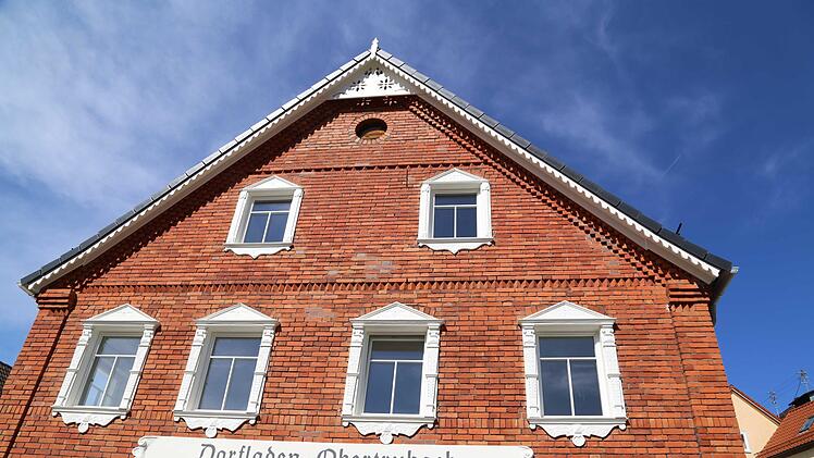 Die Backsteinfassade mit weißer Einrahmung der Fenster am Dorfladen Foto: Franz Galster