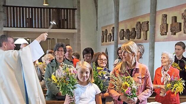 Kaplan Pawel Hardej besprengte die Kr&auml;uterb&uuml;schel mit Weihwasser.  Foto: Bruno Prei&szlig;inger