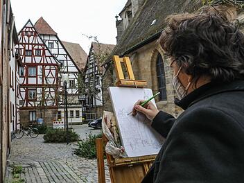 Der Bamberger Künstler Akulov Maxim zeichnet den Forchheimer Magistratsbau und die Martinskirche zunächst mit Bleistift. Foto: Barbara Herbst