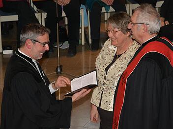 Dekan Dr. Matthias Büttner (links) entband Pfarrer Joachim Büttner (rechts) offiziell von seinen Verpflichtungen - dem Ruhestand steht nun nicht mehr im Weg. Auf dem Foto ist außerdem die Frau von Joachim Pennig, Marion Pennig (Mitte) zu sehen. Foto: Björn Hein