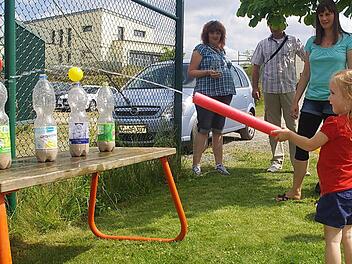 Sina spritzt mit der Wasserpistole Bälle von einer Flasche. Fotos: Heike Schülein