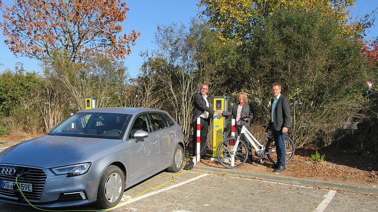 Zur Inbetriebnahme der neuen Ladesäulen für Elektro-Autos schenkteChristine Pfaff, Kommunalbetreuerin des Bayernwerks,   Bürgermeister Andreas Sandwall und Kurdirektor Thomas Beck ein Elektrofahrrad.  Stefanie Tapprogge