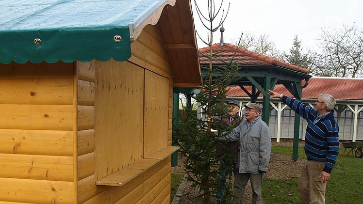 Gerhard Werner, Albert Graser und Gerhard Reuß stellen an einer Bude Christbäume auf.