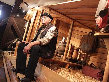Museumsführer Dieter Murmann sitzt auf einem nachgebauten Floß. Zu sehen ist dieses im Flößermuseum in Unterrodach.  Fotos: Maximilian Glas