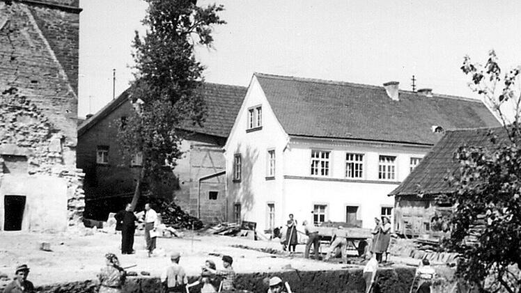 Kirchenneubau Sankt Georgskirche in Wittershausen im Jahre 1957: Neben der mehr als 700-jährigen Dorfgeschichte wurde beim großen Jubiläumsfest im Jahre 2017 auch an das 60-jährige Bestehen des neuen Wittershäuser Gotteshauses erinnert. Am alten Schulgebäude (weißes Gebäude auf dem Foto) am Kirchenvorplatz wurde nun die Metalltafel an der Fassade angebracht.