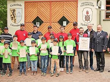 Die Mitglieder der Kinderfeuerwehr und der Ehrenvorsitzende Matthias Rosenzweig (Vierter v. r.) präsentieren die Gründungsurkunden. Mit auf dem Bild: Bürgermeister Wolfgang Möhrlein (Dritter v. r.), KBM Udo Winkler (Zweiter v. r.) und KBI Stefan D...