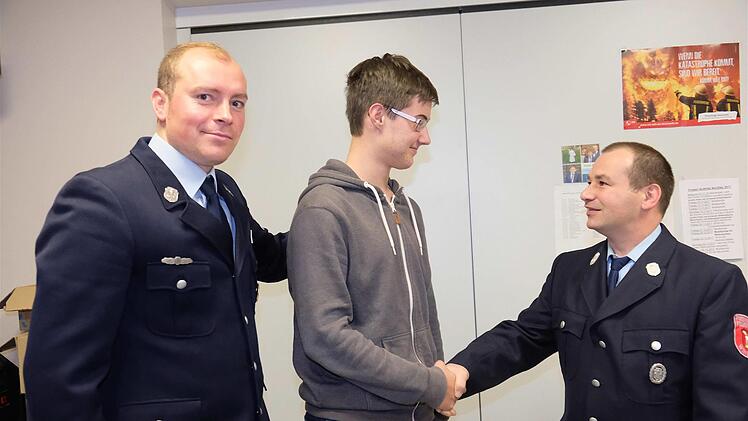 Mit dem traditionellen Handschlag begrüßten Kommandant Uwe Schumm (rechts) und Vorsitzender Christian Ullich den jugendlichen Neuzugang Xander Blum. Foto: Gerd Schaar