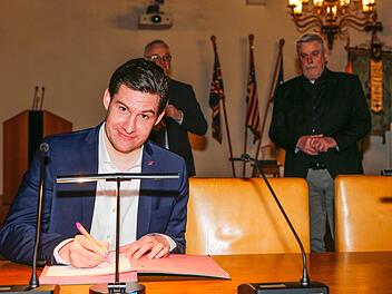 Dominik Sauerteig unterzeichnet die Annahmeerklärung, OB Norbert Tessmer (rechts) und Wahlleiter Willi Kuballa wachen im Hintergrund. Foto: Matthias Hoch