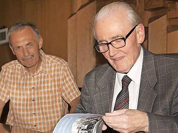 Autogrammstunde mit dem Autor: Neustadts ehemaliger Kulturamtsleiter, Dieter Seyfarth (links), lässt sich ein Buch von Helmut Scheuerich signieren. Foto: Berthold Köhler