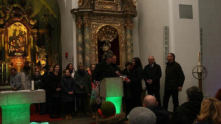 In ungewohnte Farben ist die Frensdorfer Kirche getaucht. Diakon Alfred Beyer und die Journalistin Alexandra Rank rufen zur Besinnung auf. Fotos: Werner Baier