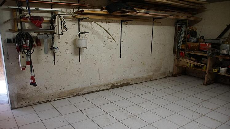 Auch die Wand in der Werkstatt zeigt, wie hoch der Schlamm durch die Räume floss.