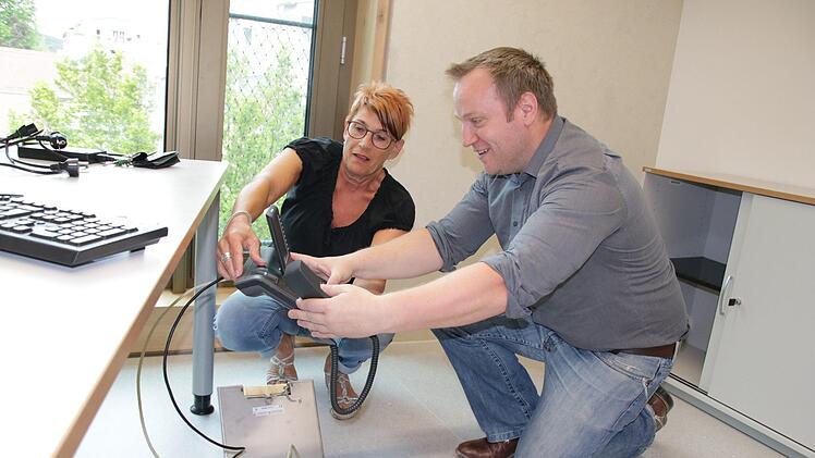 Jürgen Bischoff, Leiter Hauptverwaltung und IT, stöpselt mit seiner Kollegin Brigitte Reinhard das Telefon in seinem neuen Büro an. Die Techniker zogen als erstes um, um alles zu testen. Foto: Ralf Ruppert