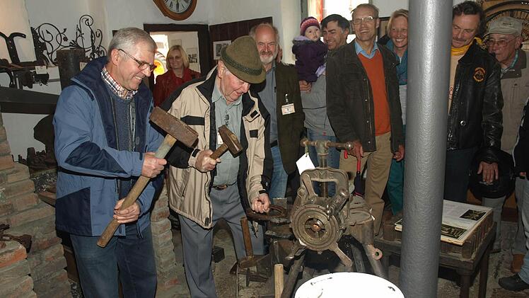 Einblicke in die Kunst des Schmiedens gab Herbert Baus (links) aus Untererthal beim Museumsfest in Ebenhausen. Daneben Museumsleiter Bernhard Wahler sowie interessierte Gäste.  Foto: Stefan Geiger