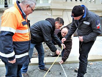 Vermessungsamtsleiter Albert Köder (von links) beobachtet die neuen Feldgeschworenen Andreas Emmerth, Holger Murk) und Christoph Kreps  bei der Übung zur Sicherung eines Grenzsteins mit Lot, Maßband und Zollstock. Foto: Sigismund von Dobschütz