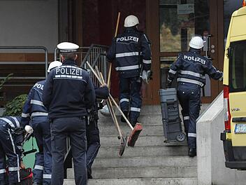 Kriminalbeamte der Spurensicherung auf dem Weg in die Behindertenwerkstatt: 14 Menschen sind bei einem Brand in der Einrichtung ums Leben gekommen. Foto: dpa