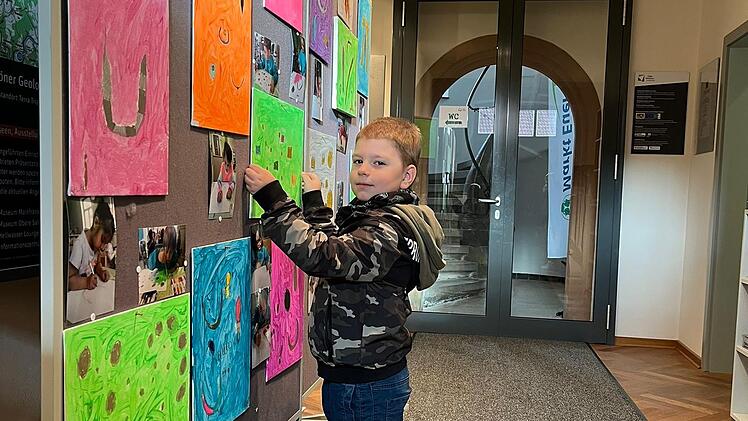 Finn selbst hängt sein Kunstwerk zum Ende der Ausstellung von Wand im Museum Terra Triassica ab.