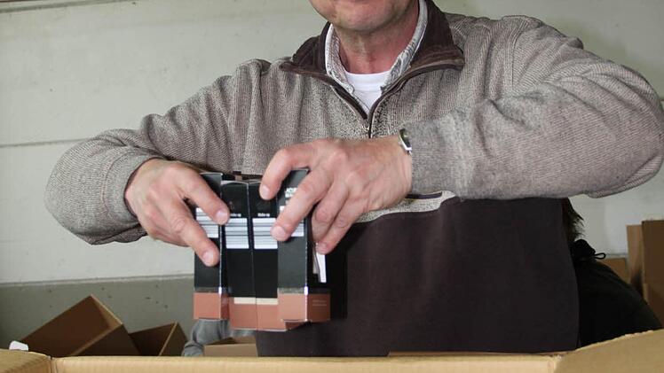 Fernando Masso stapelt die Schachteln in einen Karton