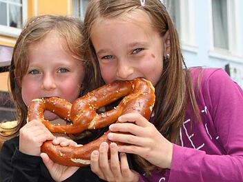 Schwestern mit Biss: Paulina und Emilia aus Züntersbach lassen sich eine Riesen-Brezel schmecken. Fotos: Ulrike Müller