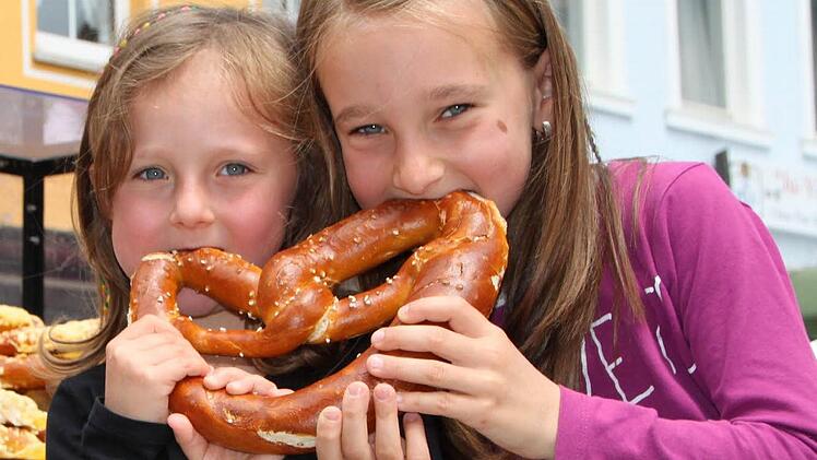 Schwestern mit Biss: Paulina und Emilia aus Züntersbach lassen sich eine Riesen-Brezel schmecken. Fotos: Ulrike Müller