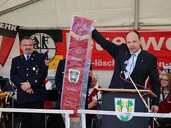 Klaus Kaufmann übergibt das Vereinsband, das die Freiwillige Feuerwehr Euerdorf zum 150. Jubiläum von den örtlichen Vereinen geschenkt bekommen hat. Links: stellv. Kommandant Dieter Stöhling.Doris Bauer