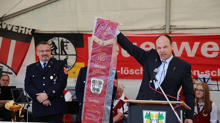 Klaus Kaufmann übergibt das Vereinsband, das die Freiwillige Feuerwehr Euerdorf zum 150. Jubiläum von den örtlichen Vereinen geschenkt bekommen hat. Links: stellv. Kommandant Dieter Stöhling.Doris Bauer