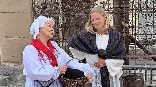 Die mitteilsamen Marktfrauen sind am Marktbrunnen im Gespräch.
