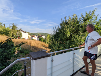Arnulf Hochmuth blickt von seinem Balkon auf das Grundstück nebenan, auf dem das Haus seines Sohnes entstehen sollte.