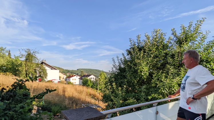 Arnulf Hochmuth blickt von seinem Balkon auf das Grundstück nebenan, auf dem das Haus seines Sohnes entstehen sollte.