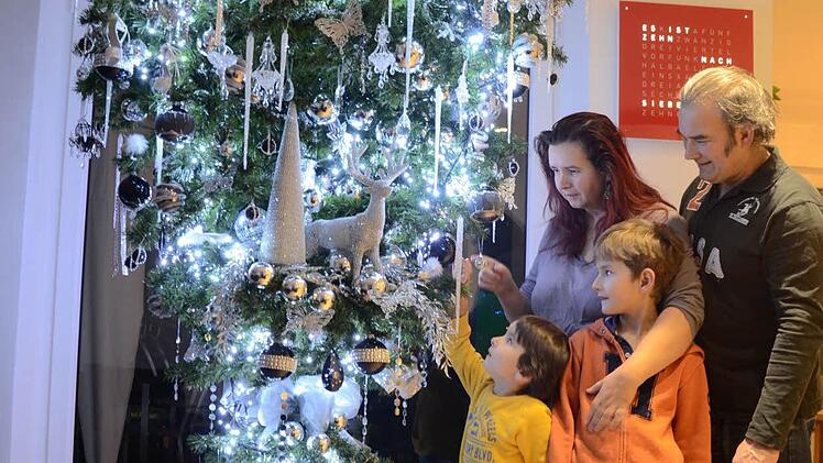 Riccardo (l.) und Raphael bestaunen ihren ganz besonderen Weihnachtsbaum. Mit ihnen freuen sich Maria Fey-Uschbanok und Ehemann Armin. Fotos: Roppelt