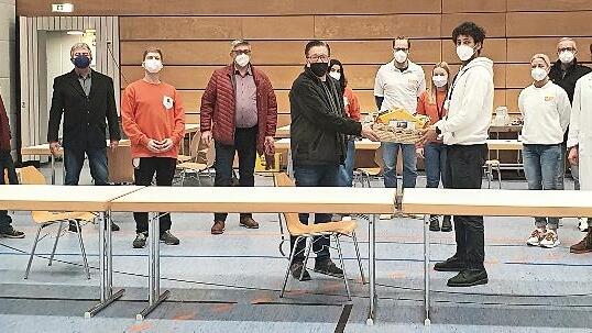 B&uuml;rgermeister Karsten Fischkal (Mitte) &uuml;berreicht John Winkler den Geschenkkorb; rechts im blauen Shirt Dr. Frank Gottwald, daneben im wei&szlig;en Mantel Dr. Konrad Merten.