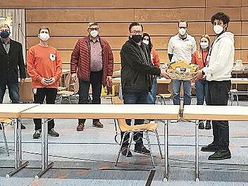 Bürgermeister Karsten Fischkal (Mitte) überreicht John Winkler den Geschenkkorb; rechts im blauen Shirt Dr. Frank Gottwald, daneben im weißen Mantel Dr. Konrad Merten.