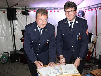 Klaus Killinger (l.) von der Dachstadter Feuerwehr und Heinz Igel aus Pommer unterzeichnen den Vertrag. fra-press