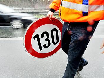 Ein Mitarbeiter der Autobahnmeisterei trägt auf der Autobahn 661 bei Frankfurt ein Schild zur Höchstgeschwindigkeit von 130 Stundenkilometern. Damals waren hier Tempolimits aufgehoben worden.  Foto: Marius Becker/dpa