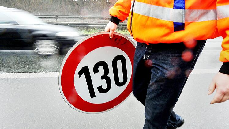 Ein Mitarbeiter der Autobahnmeisterei trägt auf der Autobahn 661 bei Frankfurt ein Schild zur Höchstgeschwindigkeit von 130 Stundenkilometern. Damals waren hier Tempolimits aufgehoben worden.  Foto: Marius Becker/dpa