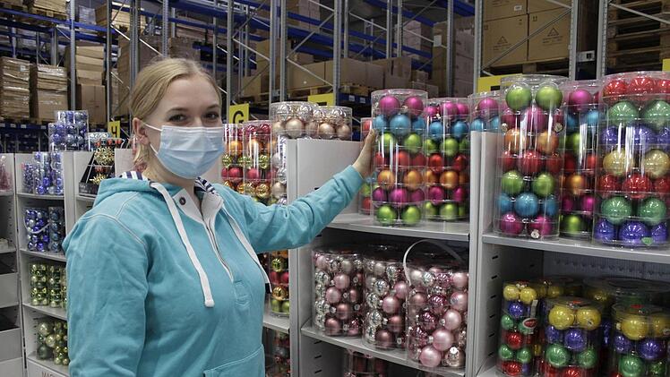 Marie M&uuml;ller-Blech aus der Marketing-Abteilung muss dieses Jahr auch im Verkauf mitanpacken. Zum Gl&uuml;ck kennt sie sich aus mit den Produkten und ber&auml;t auch gern. Die gro&szlig;e Packung mit bunten Christbaumkugeln ist dieses Jahr einer der Verkaufsschlager. Foto: Marieke Fiala