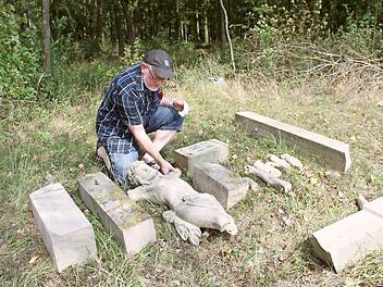 100 Jahre nach seiner Aufstellung wurde ein unter Denkmalschutz stehendes Feldkreuz bei Großwenkheim durch einen Unfall stark beschädigt und besteht nur noch aus Einzelteilen. Kreisheimatpfleger Christian Neugebauer informierte sich vor Ort über den Schaden. Foto: Heike Beudert