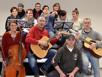 Das musikalische Dutzend: Vorne die Band foUr mit Lena Wolf (Cello), Willi Kirchner (Gitarre), Frank Wehner (Cajon) und Philipp Kirchner (Gitarre), und die Background-Truppe (2. Reihe, von links): Simone Kröckel, Silvia Wehner, Claudia Müller, Bettina Albert, Anna Quast sowie hinten (von links): Angelika Fuß, Torsten Endres und Sandra Schölzke. Foto: Kathrin Kupka-Hahn