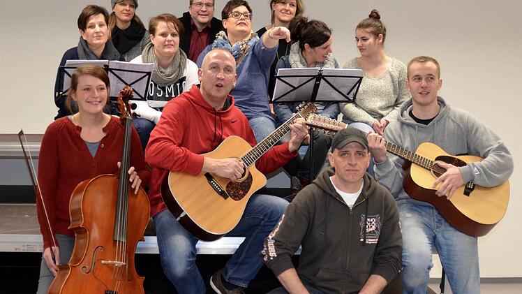Das musikalische Dutzend: Vorne die Band foUr mit Lena Wolf (Cello), Willi Kirchner (Gitarre), Frank Wehner (Cajon) und Philipp Kirchner (Gitarre), und die Background-Truppe (2. Reihe, von links): Simone Kröckel, Silvia Wehner, Claudia Müller, Bettina Albert, Anna Quast sowie hinten (von links): Angelika Fuß, Torsten Endres und Sandra Schölzke. Foto: Kathrin Kupka-Hahn