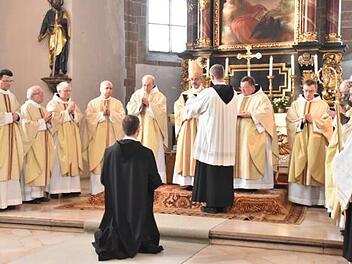 Frater Patrick kniet vor dem Abt und den Priestern. Er hat sich entschieden, Mönch "auf Zeit" zu werden.  Foto: privat